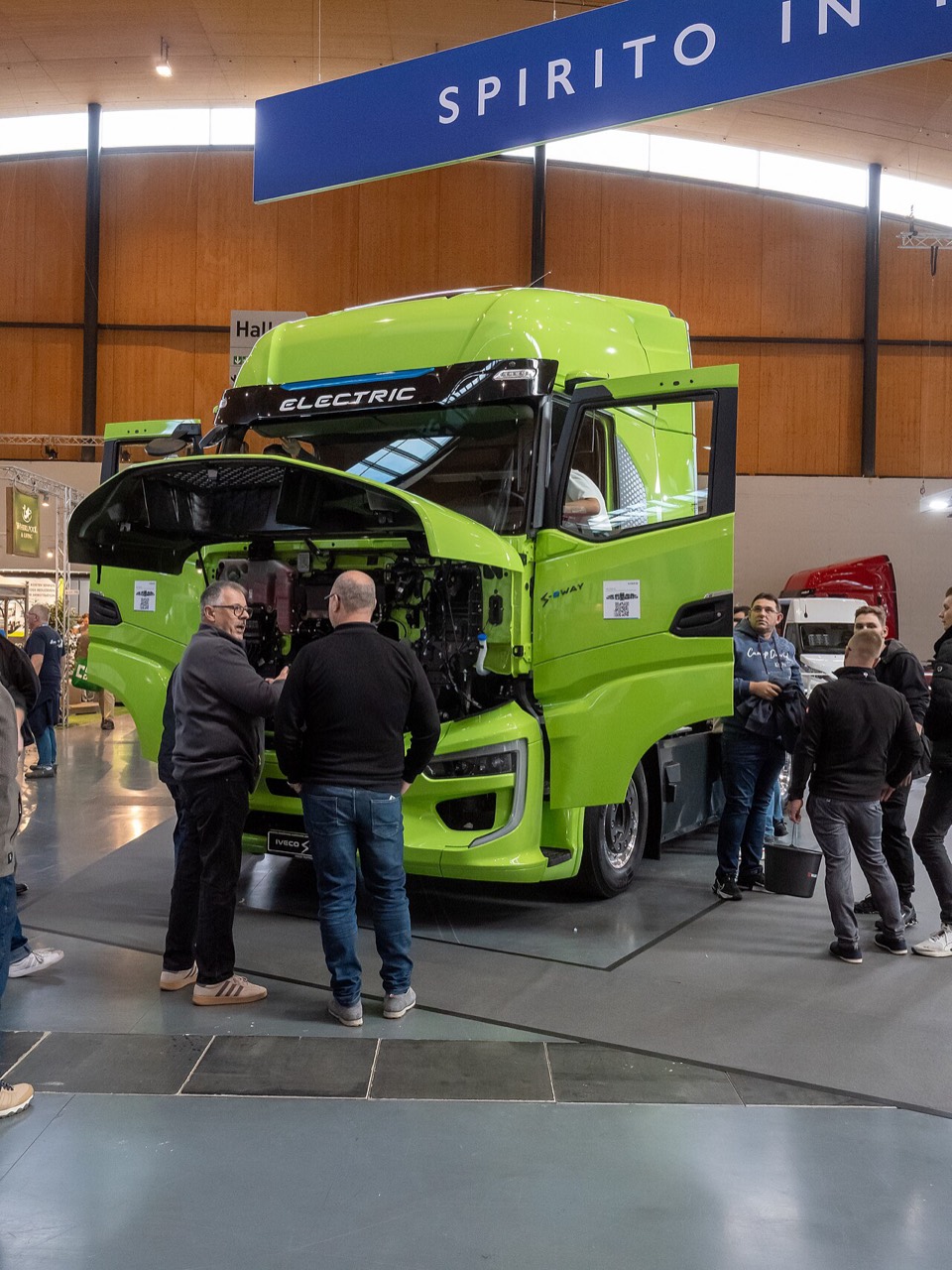 Grüne elektrische IVECO S-eWay Sattelzugmaschine mit geöffneter Front auf der NUFAM 2025