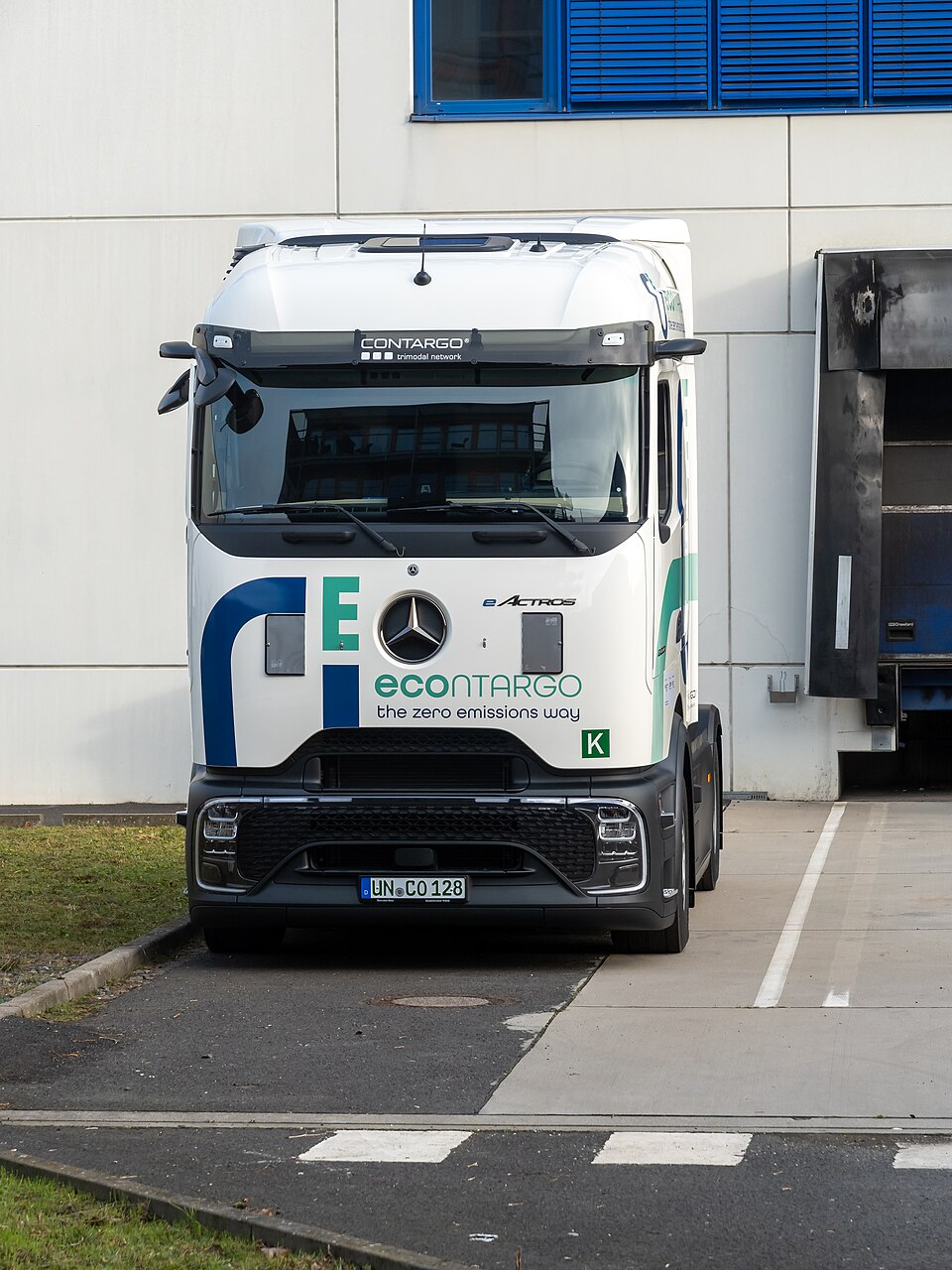 Frontalansicht eines weißen Mercedes-Benz eActros 600 von Contargo vor einem Logistikgebäude