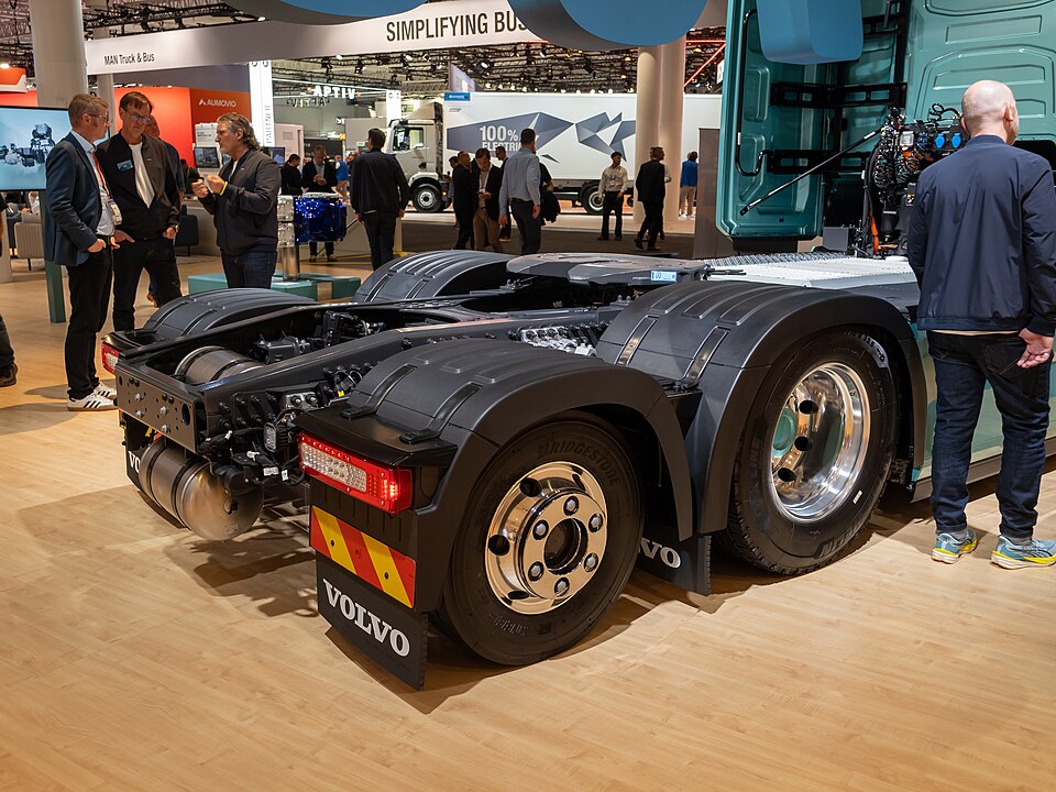 Detailansicht der beiden Hinterachsen und der Sattelkupplung eines türkisfarbenen Volvo FH Aero Electric